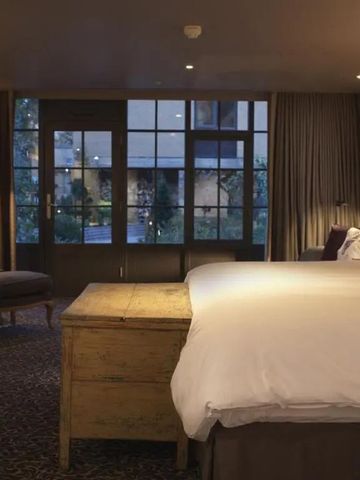 Elegantes modernes Hotelzimmer mit großem Bett und Fenster im Lygon Arms.