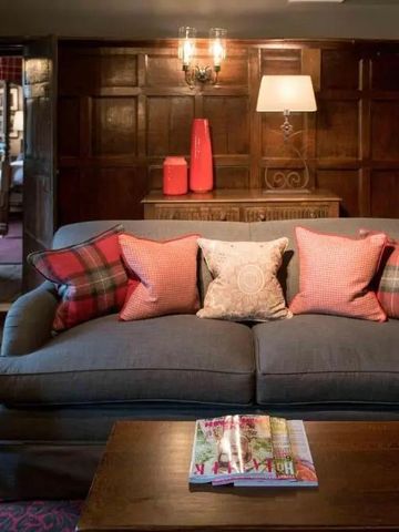 Gemütliche Lounge mit bequemen Sofas und Holzwänden im Lygon Arms.