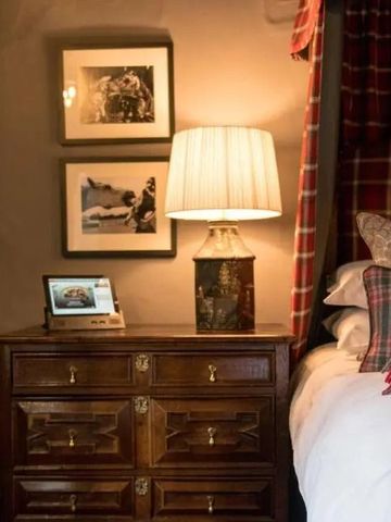 Gemütliches Zimmer mit Holzkommode und warmem Lampenlicht