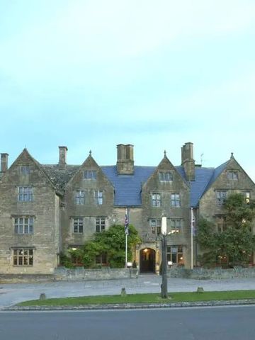 Historische Fassade des Hotels mit Steingebäude und grüner Umgebung