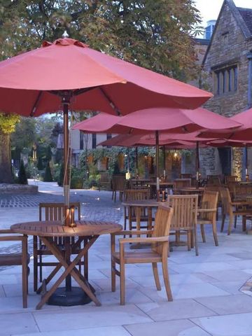 Terrasse mit roten Sonnenschirmen und Holzmöbeln