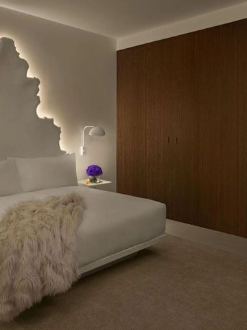 Abendliches Zimmer mit beleuchtetem Wanddekor und stilvollen Möbeln