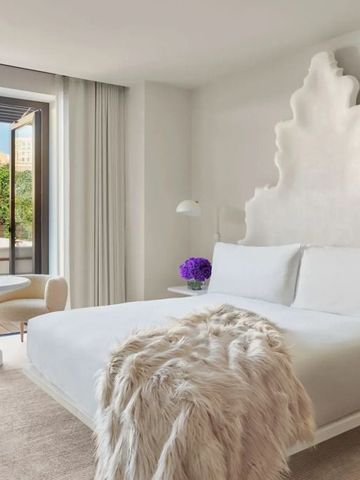 Modernes Hotelzimmer mit Balkonblick auf die Stadt und stilvoller Dekoration.