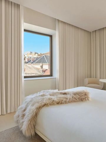 Lichtdurchflutetes modernes Hotelzimmer mit hellem Dekor und großen Fenstern.