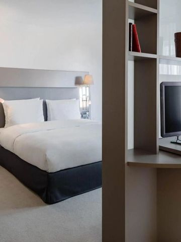 Modernes Doppelbettzimmer mit Flachbildfernseher und Lesesesseln