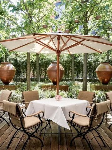 Gemütliche Terrasse mit elegant gedeckten Tischen und grüner Umgebung.