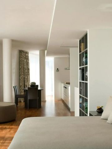 Großzügiges Zimmer mit Sitzecke und Bücherregal in modernem Design.