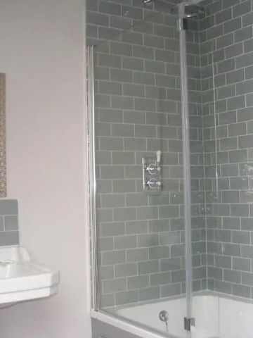 Badezimmer mit eleganten grauen Fliesen und Badewanne