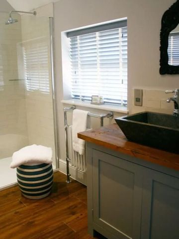 Badezimmer mit rustikalem Waschbecken und großer Dusche