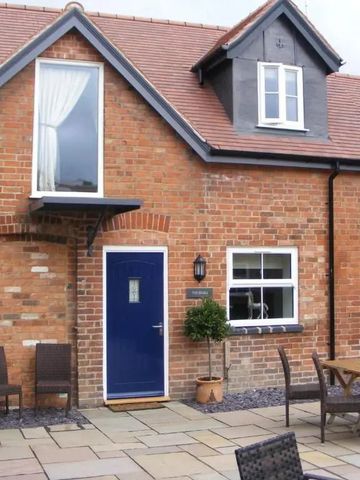 Ziegelhaus mit blauer Tür und Terrasse mit Tisch und Stühlen