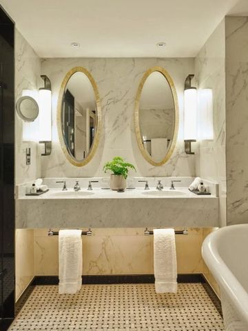 Schickes Badezimmer mit Doppelwaschbecken und Marmorverkleidung