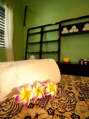 Einladender Spa-Raum mit Handtüchern und frischen Blüten auf dem Tisch.