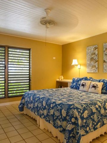 Geräumiges Schlafzimmer mit blauer Bettwäsche und Fensterläden.