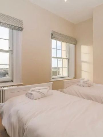 Zweibettzimmer mit großen Fenstern und Tageslicht.