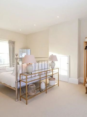 Helles Schlafzimmer mit eleganter Einrichtung und großem Bett.