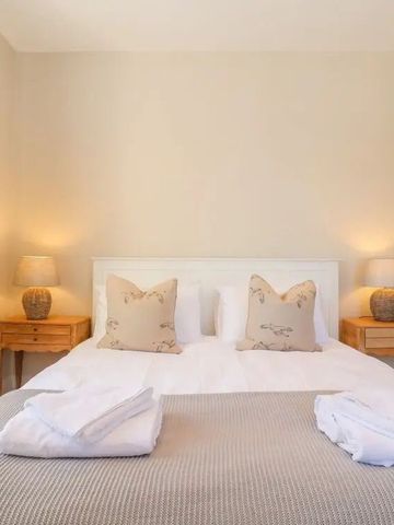 Gemütliches Schlafzimmer mit beigem Dekor und Nachttischen.