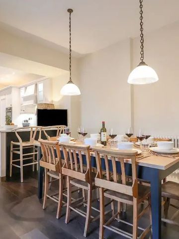 Essbereich mit großem Tisch und moderner Beleuchtung.