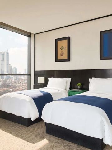 Zweibettzimmer mit großen Fenstern und Stadtblick