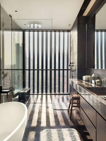 Luxuriöses Badezimmer mit freistehender Badewanne und Fensterfront