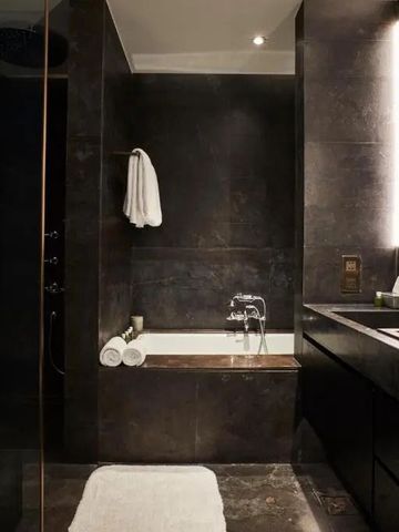 Edles Badezimmer mit dunkler Marmoroptik und moderner Ausstattung
