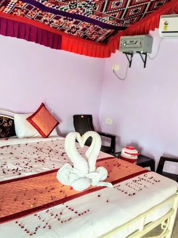 Doppelbett in einem dekorierten Zimmer mit handtuchgefalteten Schwänen.