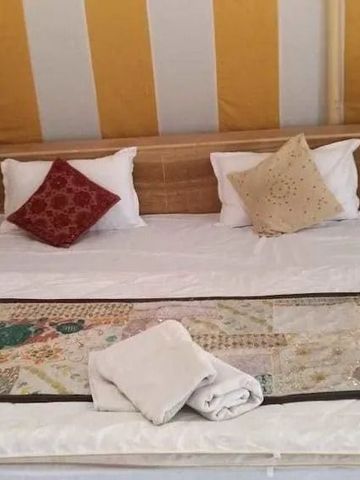 Luxuriöse Zimmereinrichtung mit bunten Kissen und handgefertigter Tagesdecke