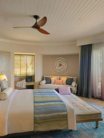 Geräumiges Schlafzimmer in einer Villa mit Meerblick durch große Fenster.