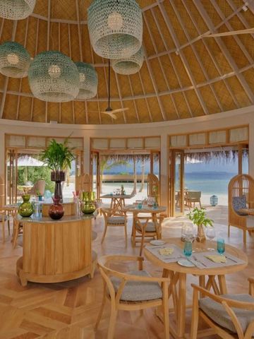 Offenes Restaurant mit Strohdach und Blick auf den Strand