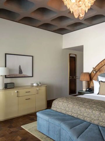 Elegantes Hotelzimmer mit Designermöbeln und kunstvollen Deckenreliefs