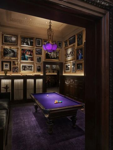 Eleganter Billardraum mit violettem Tisch und gerahmten Bildern