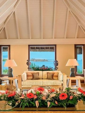 Luxuriöser Wohnbereich mit Blumen, Blick auf das Meer durch Fenster