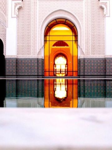 Beleuchteter Innenhof mit reflektierendem Wasserbecken im Oberoi Marrakech