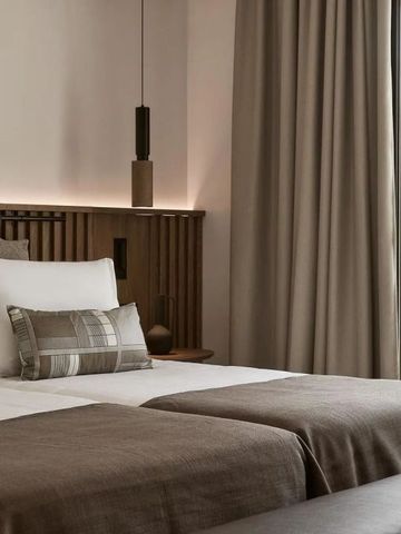 Helles Schlafzimmer mit zwei Einzelbetten und dezenter Beleuchtung