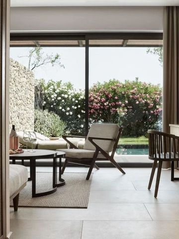 Helle Sitzgelegenheit mit Blick auf gepflegten Garten und Pool im Hintergrund