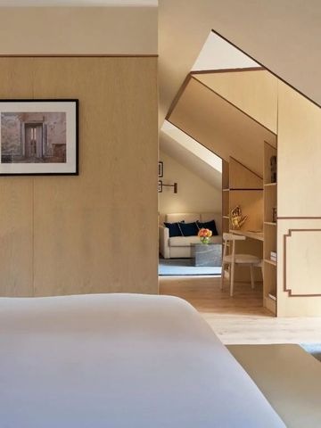 Hotelzimmer mit moderner Einrichtung und Blick auf eine kleine Sitzecke.