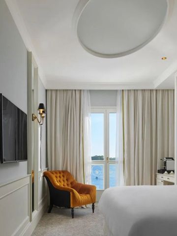 Suite mit Designer-Sessel und Blick auf die Küste.