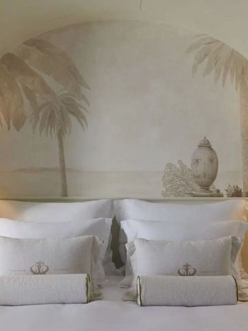 Elegantes Hotelzimmer mit stilvollen Kopfteilverzierungen und luxuriösen Kissen