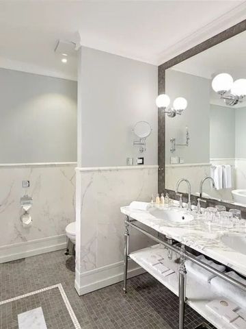 Luxuriöses Badezimmer mit großem Spiegel und eleganter Marmorausstattung