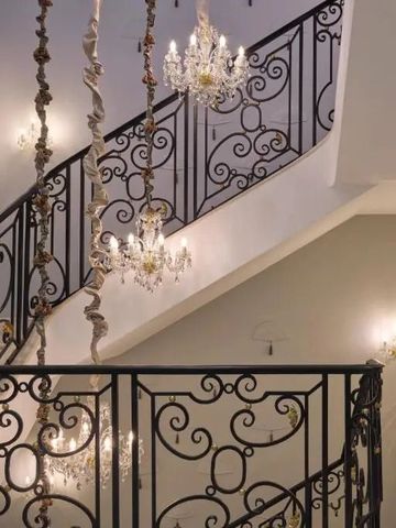 Prächtige Treppe mit kunstvollen Schmiedeeisengeländern und Kronleuchtern