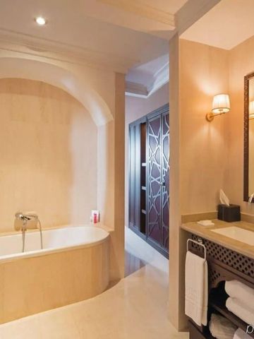 Hotelbad mit eingebauter Badewanne und eleganter Beleuchtung