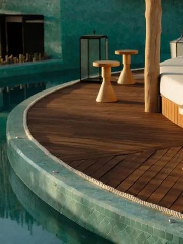 Exklusiver Poolbereich mit Holzmöbeln und Liegestühlen