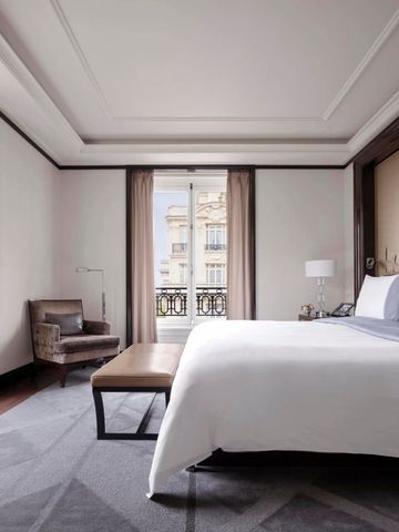 Helles Schlafzimmer mit Fensterblick und eleganten Möbeln im The Peninsula Paris
