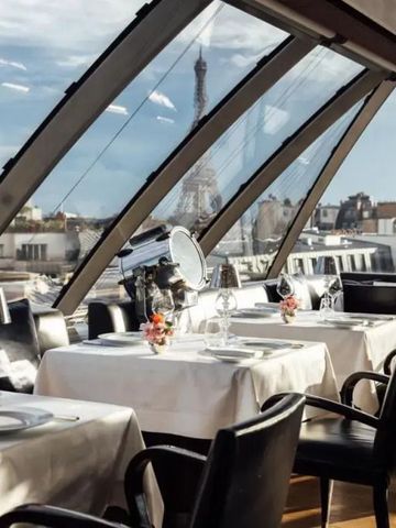 Restaurantszene mit Blick auf den Eiffelturm durch große Fenster