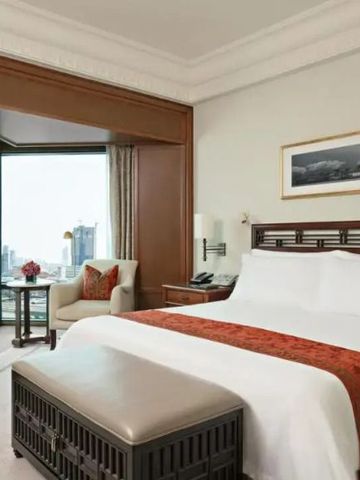 Hotelzimmer mit komfortablem Doppelbett, Sitzbereich und Aussicht auf die Stadt