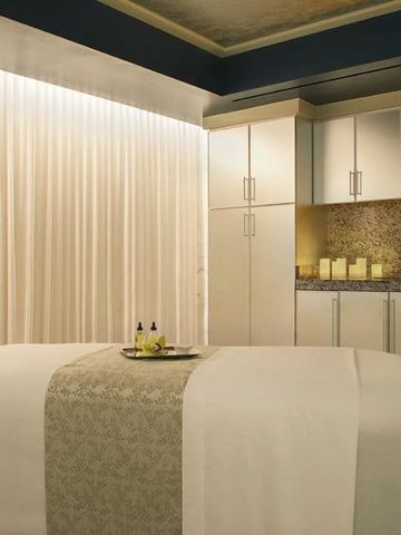 Entspannender Wellnessraum mit Massagebett, warmem Licht und Wohlfühlatmosphäre