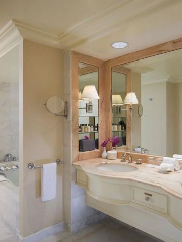 Elegantes Badezimmer in Marmoroptik mit Doppelwaschbecken und luxuriöser Ausstattung