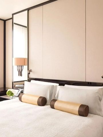 Gepflegtes Zimmer im Peninsula Hong Kong mit zwei Kissenrollen auf dem Bett