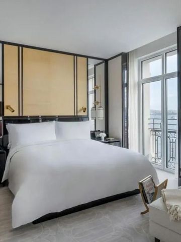 Helles Schlafzimmer mit großen Fenstern und stilvoller Einrichtung