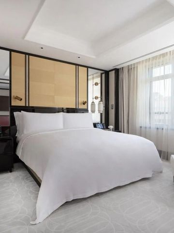 Elegantes Schlafzimmer mit großem Bett und Fenster mit Tageslicht