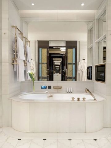 Helles, geräumiges Badezimmer mit Marmorverkleidung und moderner Ausstattung.